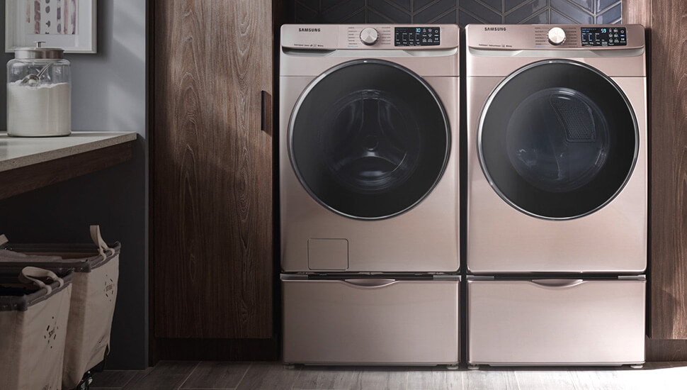 champagne front load washer and dryer on pedestals